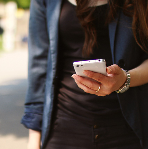 Frau hält ein weißes Smartphone in der Hand